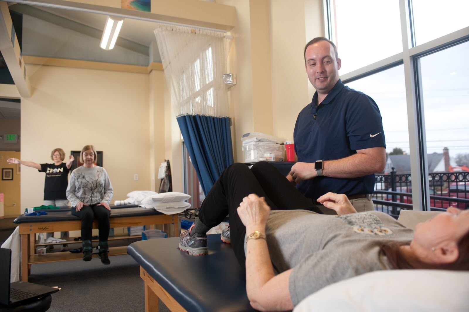 physical therapist Phillip with a patient and 2 other patients in background
