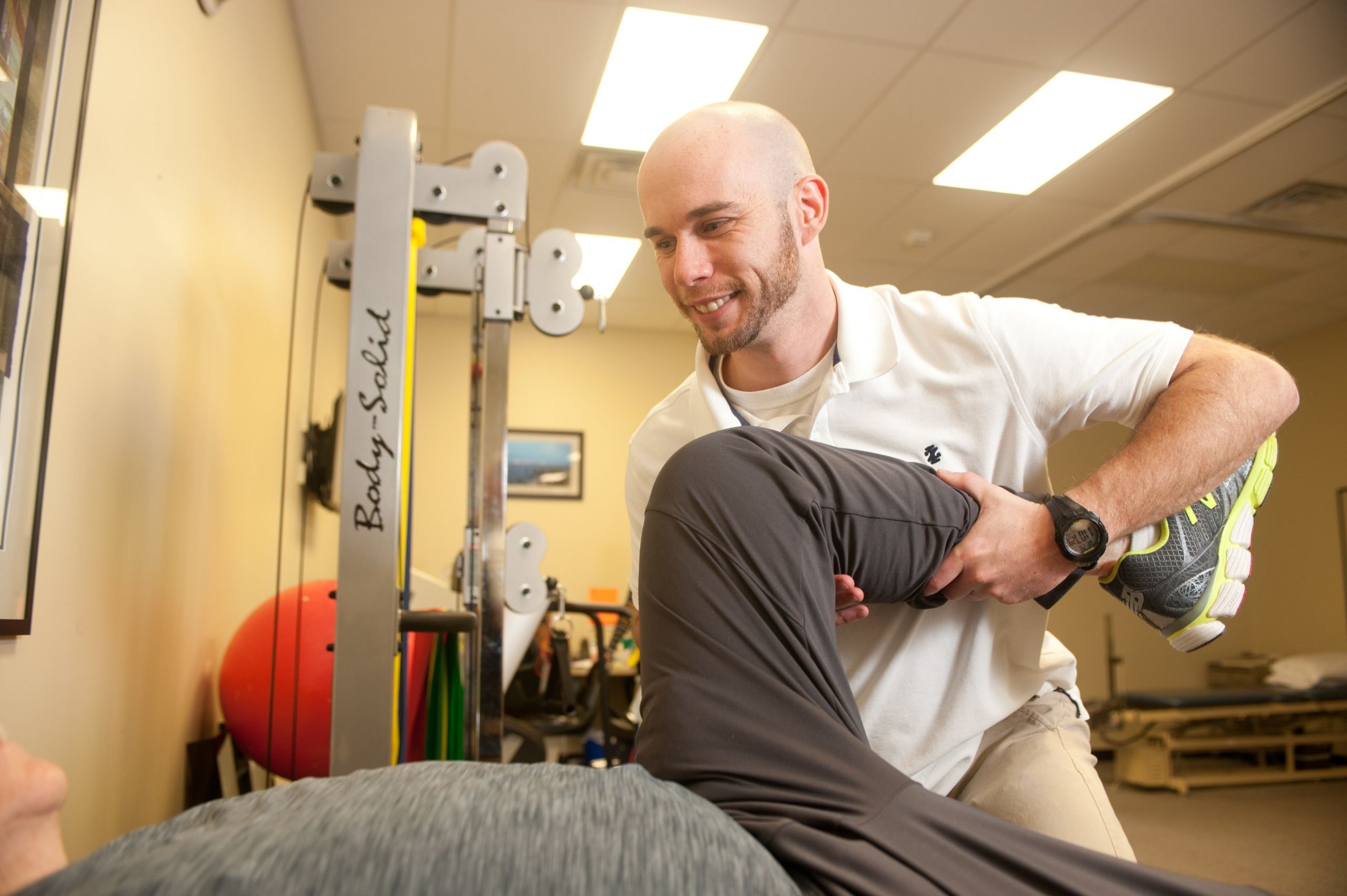 physical therapist Brian assisting with a patient's leg